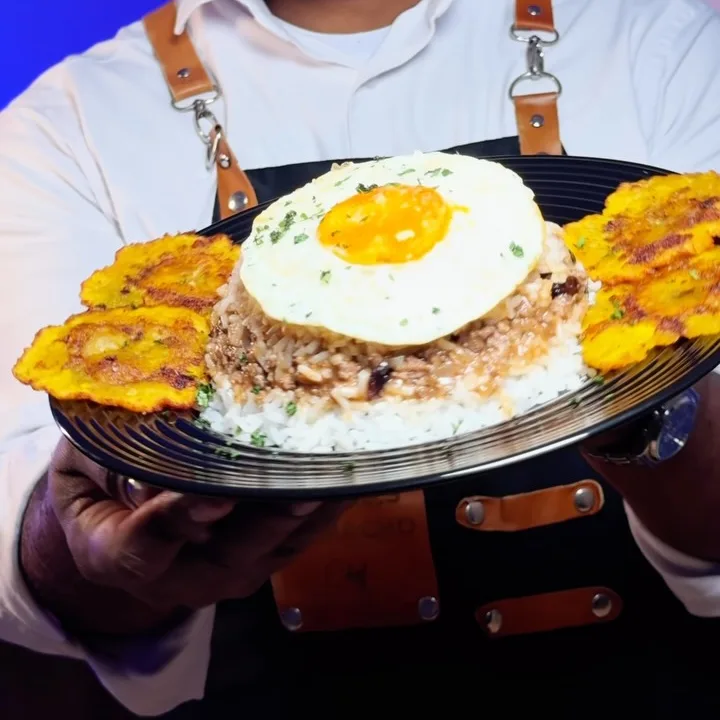 Arroz tapado coronado con un huevo frito y acompañado de plátano