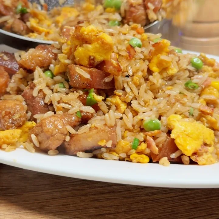 Chaufa de cerdo con huevo y vegetales servido en un plato