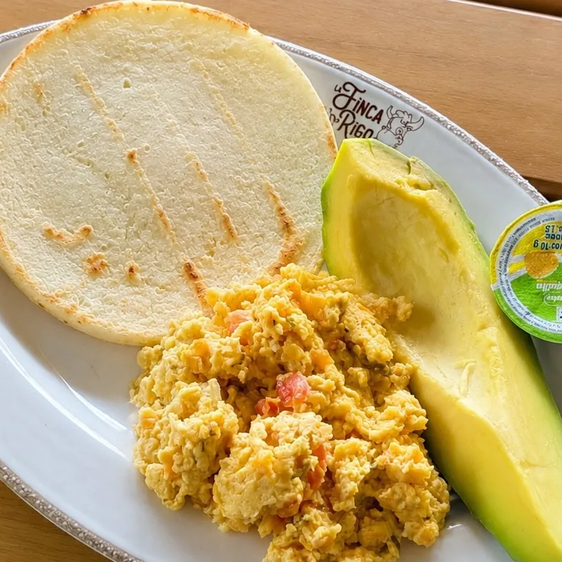 Huevos revueltos con ahogao servidos con arepa asada y aguacate