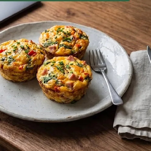 Tres muffins de huevo con jamón y hierbas en un plato