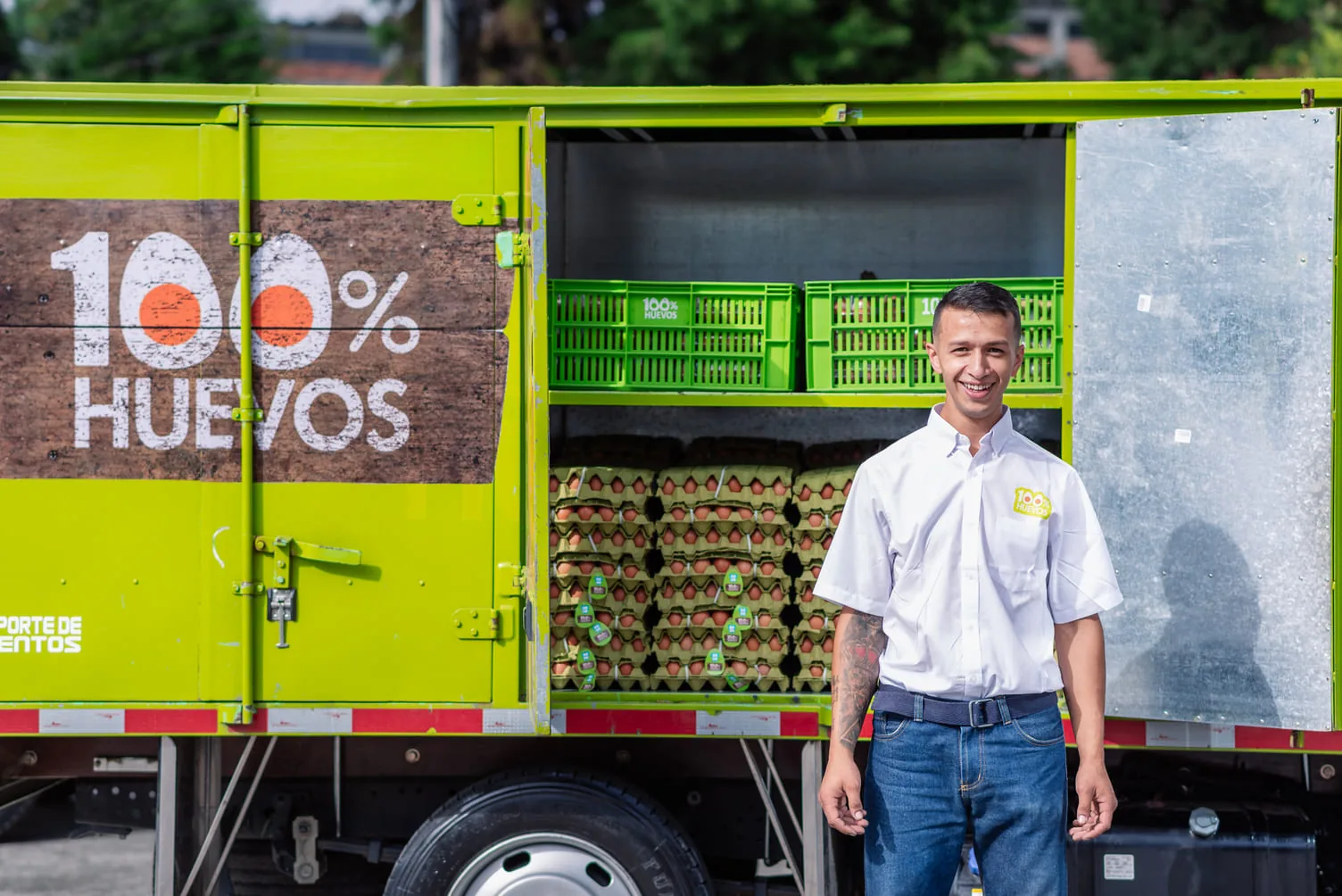 Colaborador de 100% Huevos junto al camión cargado de huevos