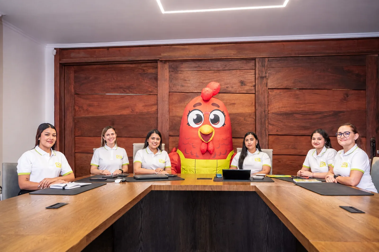 Equipo reunido en una sala con Pía, la gallina de 100% Huevos