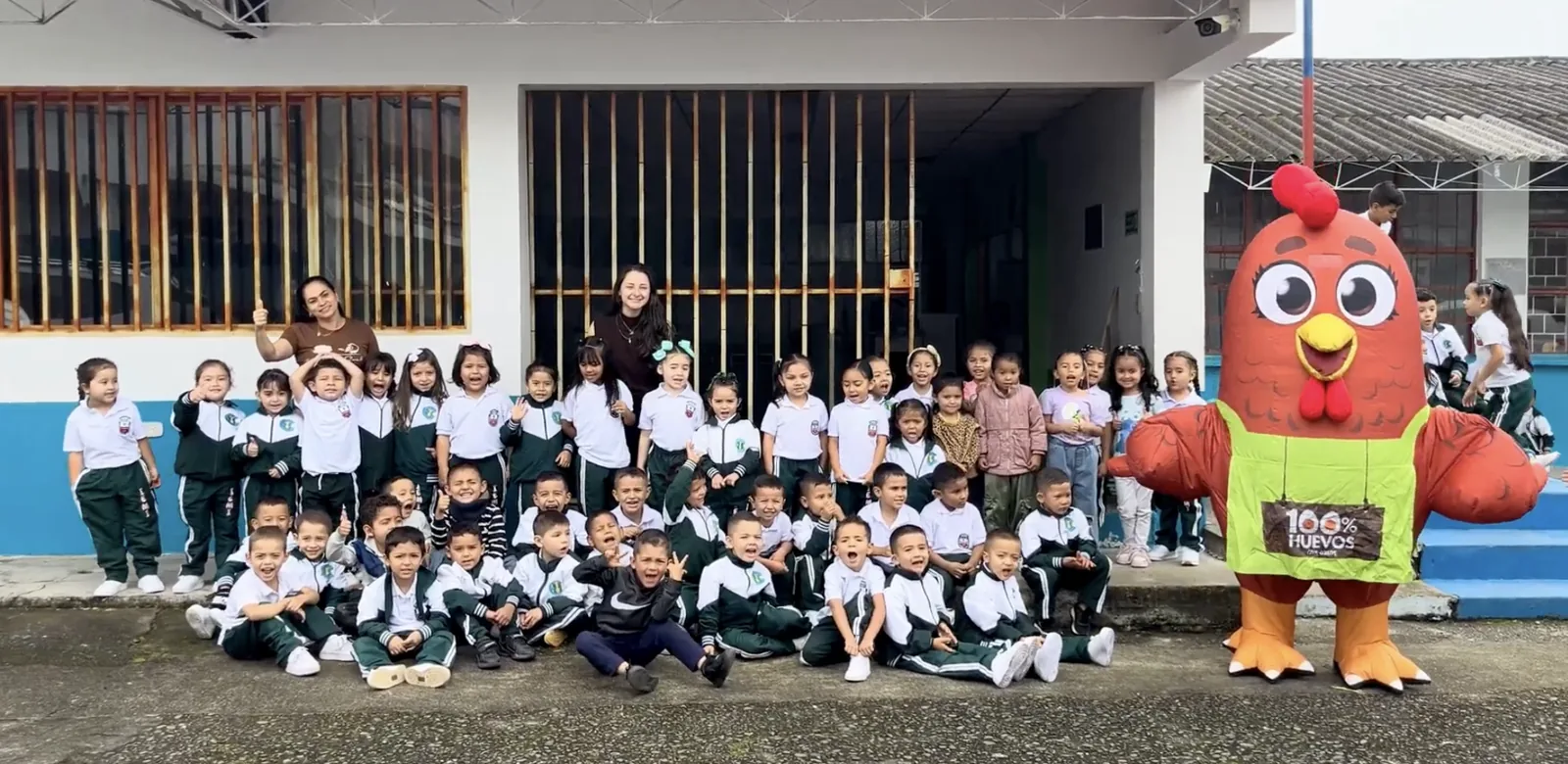 Niños y docentes de una institución educativa junto a Pía, en la entrega de kits escolares